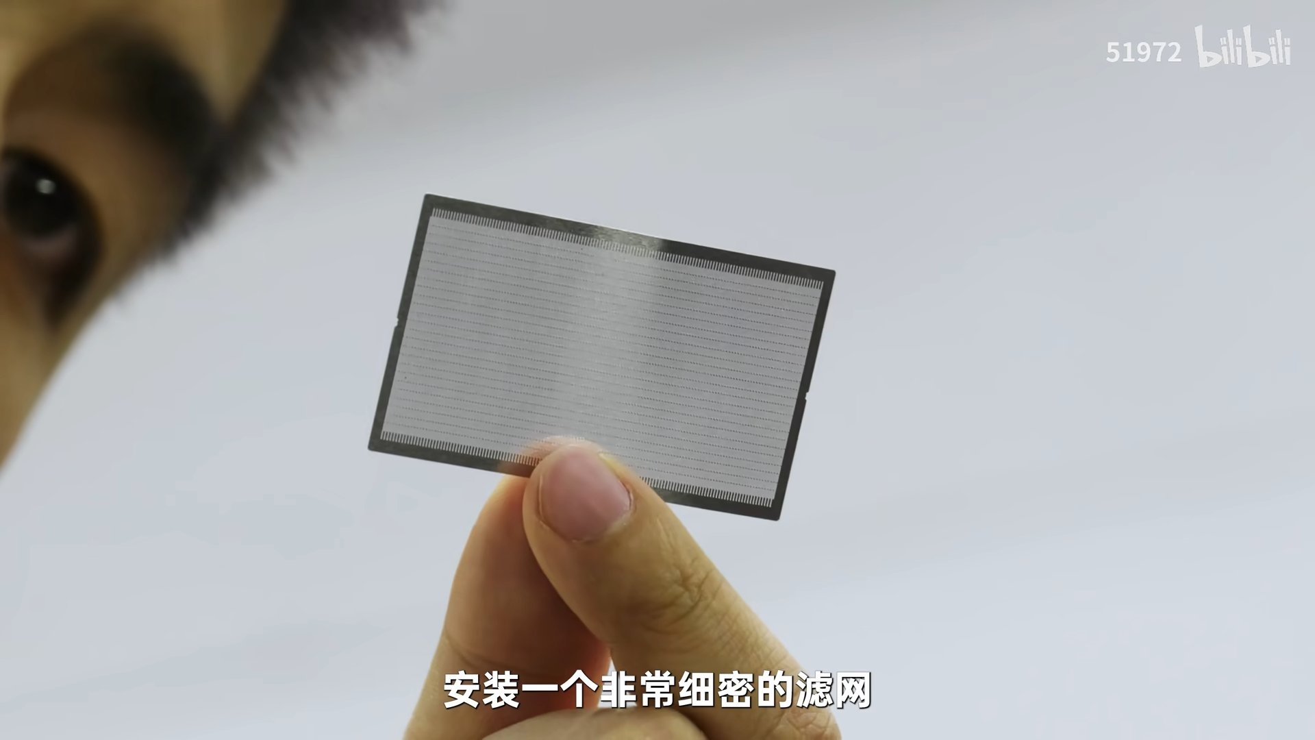 Bilibili logo and number 51972 in the corner, person holding a small rectangular screen filter close-up.