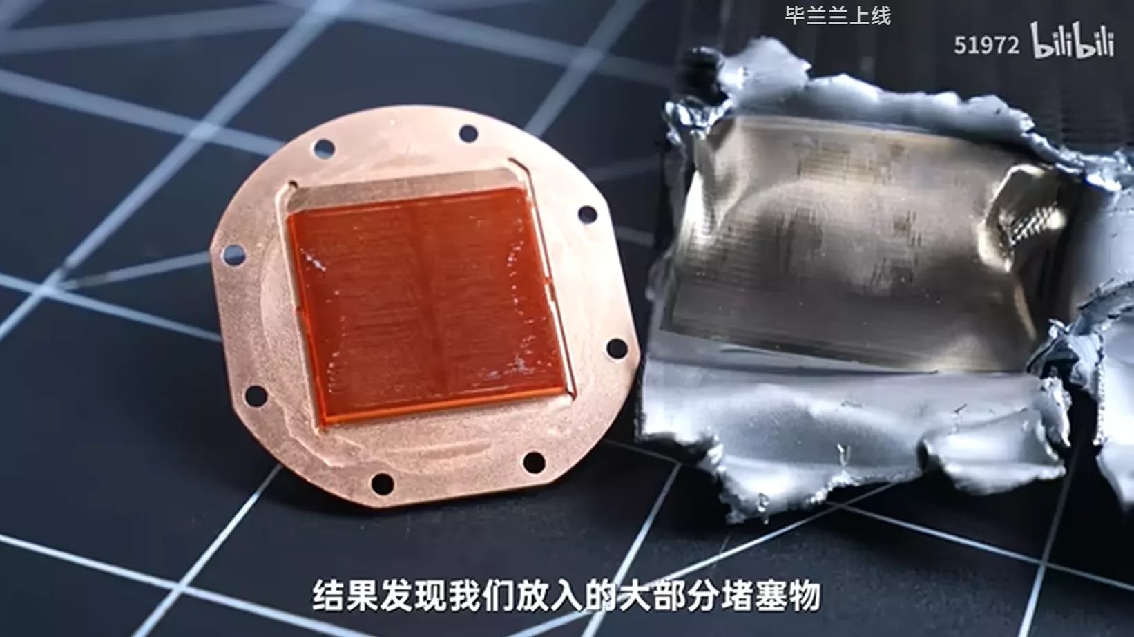 Copper heat sink with a red core next to torn metal foil on a patterned surface, text reads 结�我们大部分堵塞物 and brand bilibili.