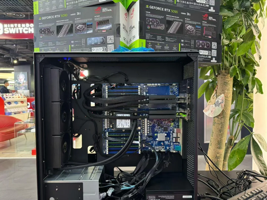 An open PC case with triple-fan cooling is surrounded by boxes labeled 'GeForce RTX 5090' and 'ROG ASTRAL' in a store setting with a Nintendo Switch display visible in the background.