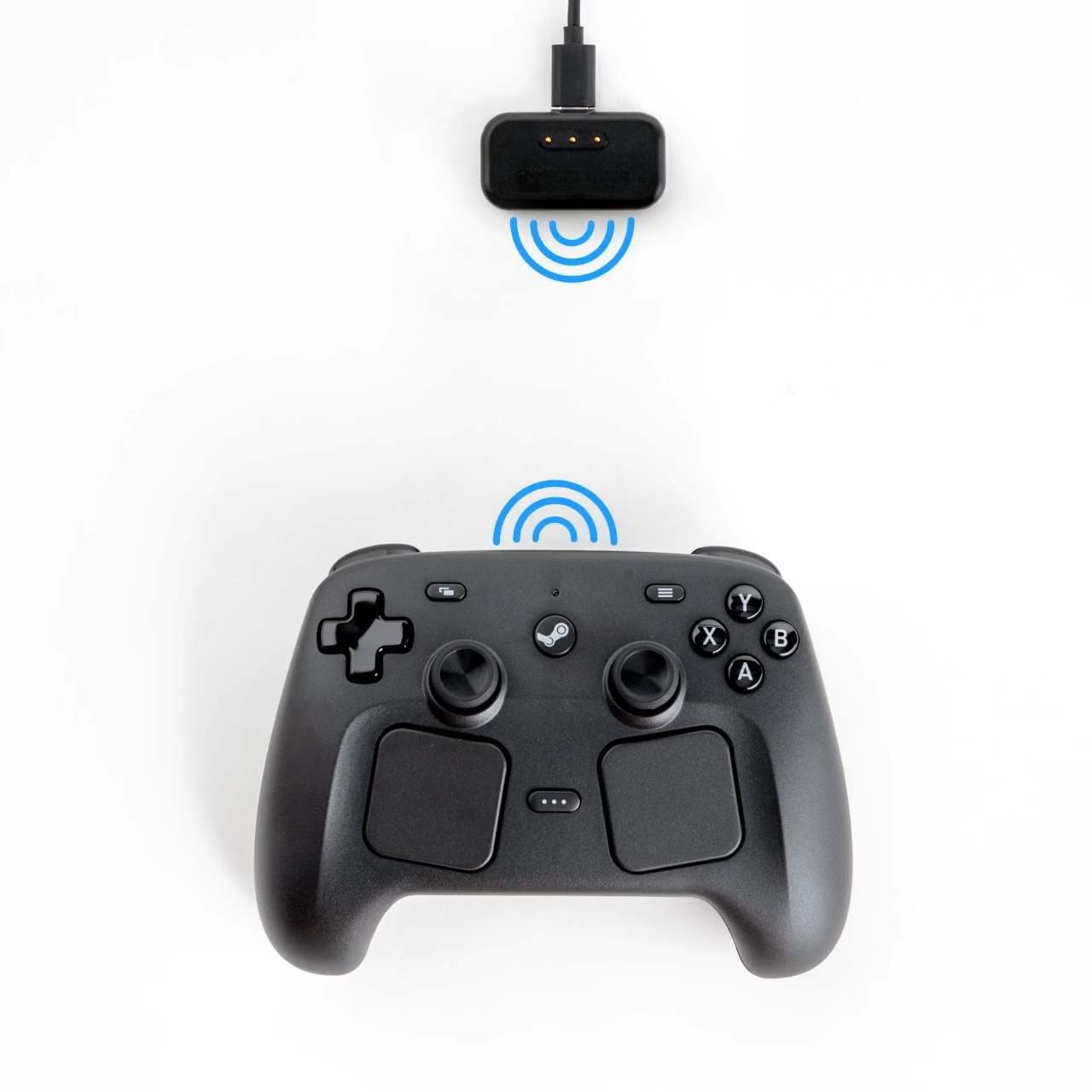 A black Steam controller with detachable wireless charging adapter, both emitting blue wireless signal icons, are shown on a white background.