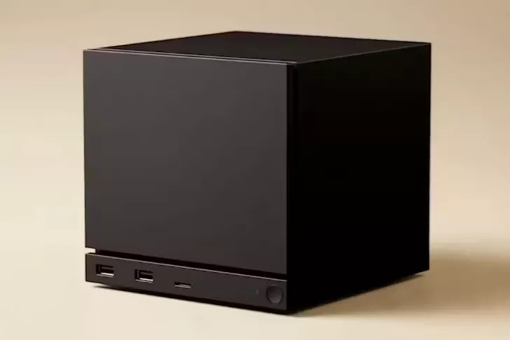 A black, cubical unbranded device with two USB ports and a power button on a beige background.