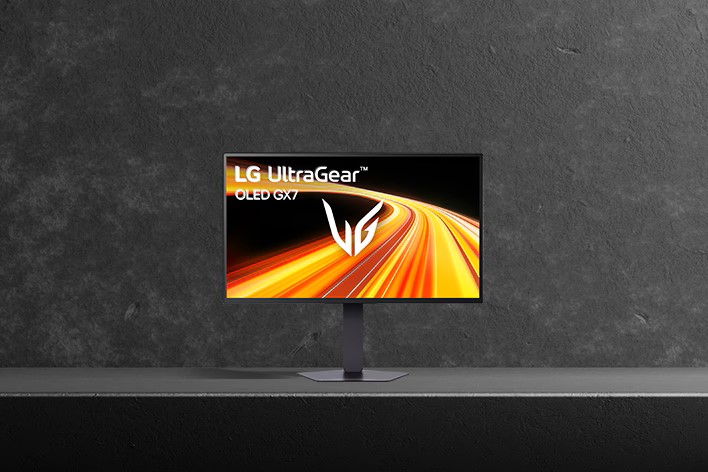 An LG UltraGear OLED GX7 monitor displaying a dynamic orange and yellow motion graphic on a stand against a dark background.